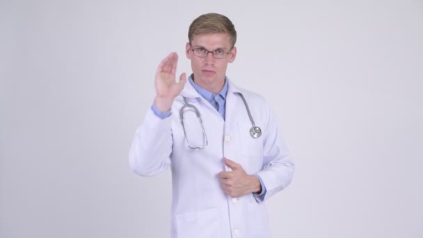Joven hombre guapo doctor mostrando stop gesture — Vídeo de stock