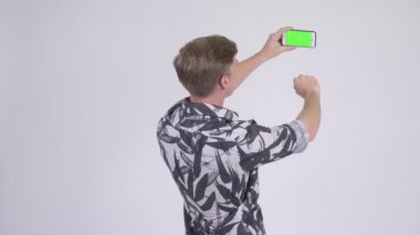 Genç yakışıklı turist adamın telefonu ile fotoğraf çekerken arkadan görünüş