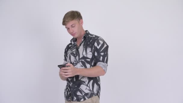 Happy νεαρό όμορφος τουριστικά άνθρωπος σκέφτεται κατά τη χρήση του τηλεφώνου — Αρχείο Βίντεο