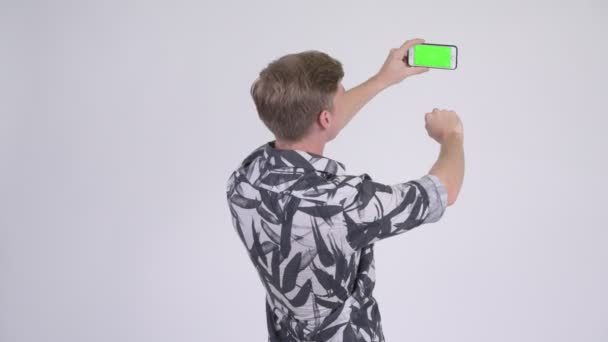 Rückansicht eines jungen gutaussehenden Touristenmannes beim Fotografieren mit dem Handy — Stockvideo