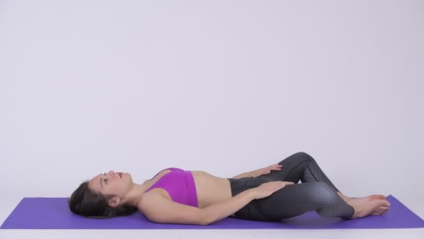 Junge schöne multiethnische Frau macht konstruktive Rest-Yoga-Pose — Stockvideo