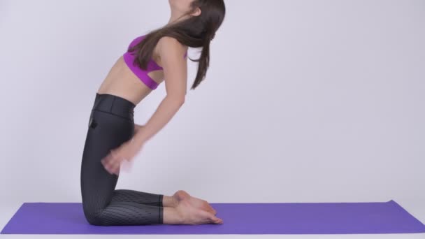 Νεαρή όμορφη γυναίκα πολυεθνικό κάνει καμήλα yoga πόζα — Αρχείο Βίντεο