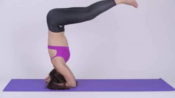 Jovem bela mulher multi-étnica fazendo Headstand ioga pose — Vídeo de Stock