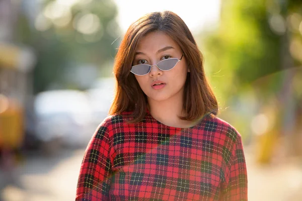 Cara de joven hermosa mujer de negocios asiática con gafas de sol al aire libre —  Fotos de Stock