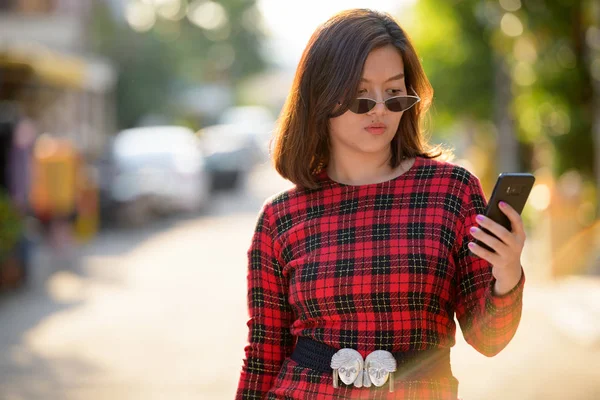 携帯電話を屋外で使う若い美しいアジア女性実業家 — ストック写真