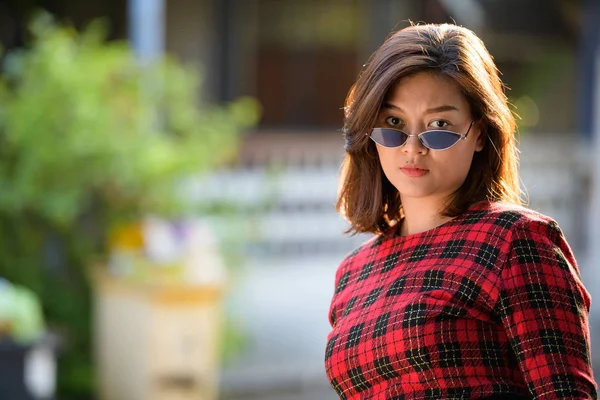 Cara de joven hermosa mujer de negocios asiática con gafas de sol al aire libre —  Fotos de Stock