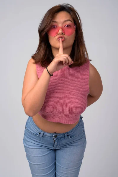 Ung Vacker asiatisk kvinna som bär hjärtat formade glasögon med finger på läppar — Stockfoto
