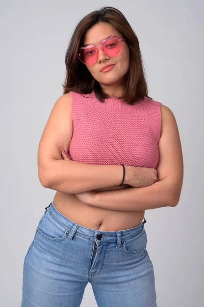 Ung Vacker asiatisk kvinna som bär hjärtformade glasögon med armarna korsade — Stockfoto