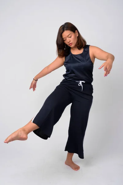 Junge schöne asiatische Frau tanzt und steht auf einem Bein — Stockfoto