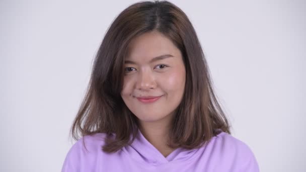Cara de joven feliz mujer asiática con el dedo en los labios — Vídeo de stock