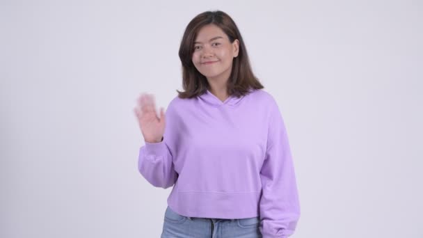 Молодая счастливая азиатка машет рукой — стоковое видео