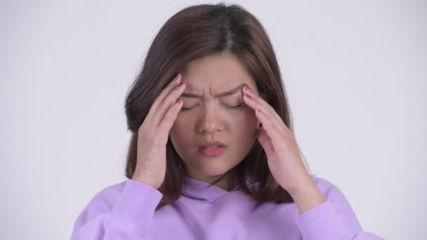Ansikte av ung stressad asiatisk kvinna att ha huvudvärk — Stockvideo