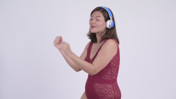 Young happy Asian tourist woman dancing and listening to music — Stock Video