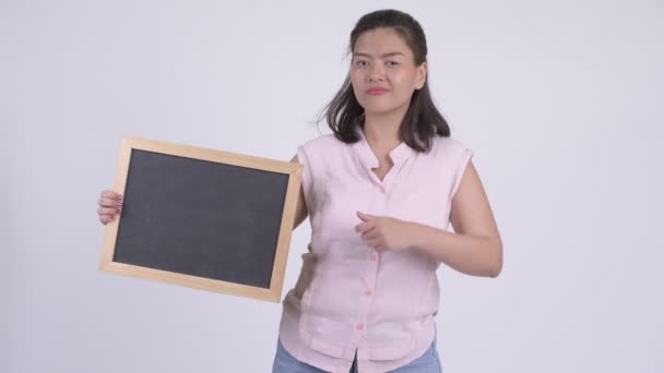 Junge gestresste asiatische Geschäftsfrau hält Tafel und drückt Daumen nach unten — Stockvideo
