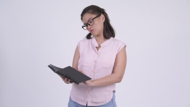 Unga glada asiatiska affärskvinna läser bok — Stockvideo