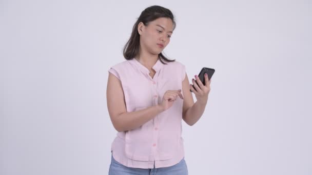 Молодая азиатская бизнесвумен, пользующаяся телефоном и получающая плохие новости — стоковое видео