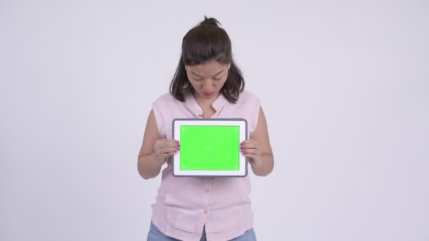 Молодая счастливая азиатская предпринимательница показывает цифровой планшет и выглядит удивленной — стоковое видео