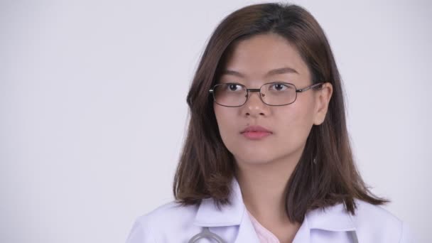 Cara de feliz joven hermosa mujer asiática médico pensando — Vídeo de stock