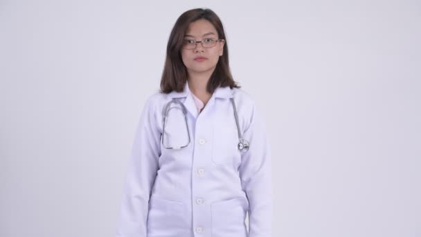 Feliz joven hermosa mujer asiática médico con los brazos cruzados — Vídeo de stock