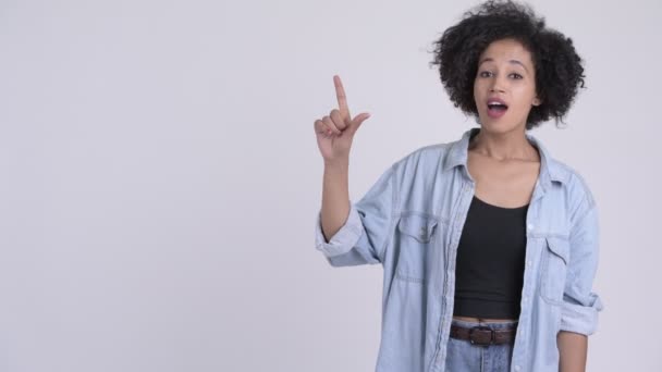 Glad ung vacker afrikansk kvinna tänkande och pekar uppåt — Stockvideo