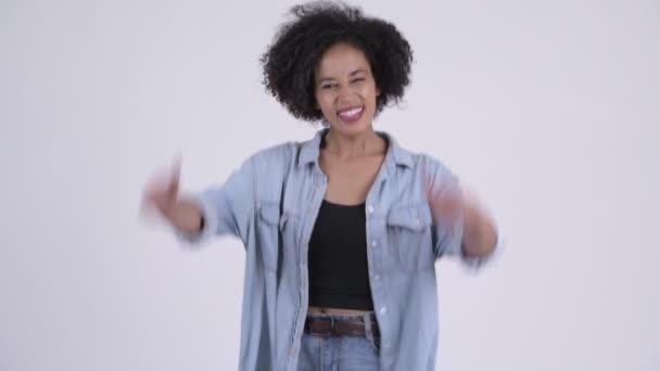 Счастливая молодая красивая африканская женщина выглядит взволнованной и подает большие пальцы — стоковое видео