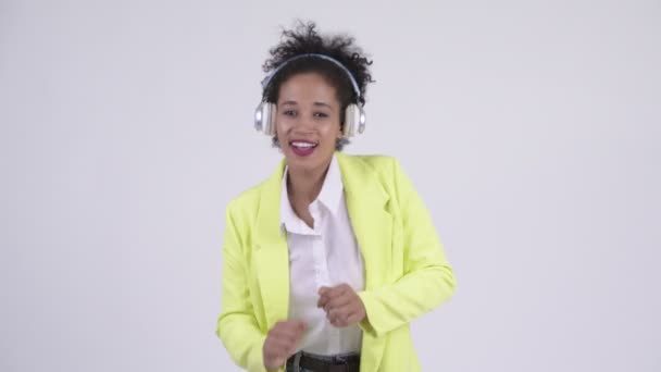 Glücklich junge schöne afrikanische Geschäftsfrau tanzt und hört Musik — Stockvideo