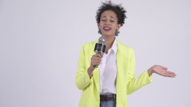 Счастливая молодая красивая африканская бизнесвумен поет с микрофоном — стоковое видео