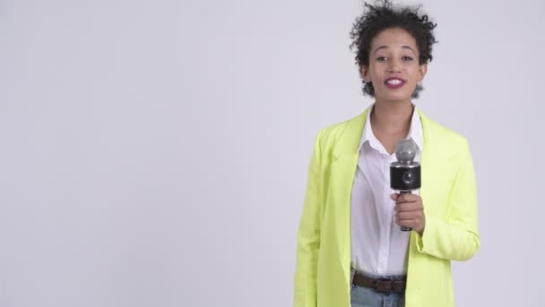Gelukkig jonge mooie Afrikaanse zakenvrouw als nieuwslezer met microfoon — Stockvideo