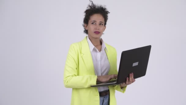 Gelukkig jonge mooie Afrikaanse zakenvrouw denken terwijl het gebruiken van laptop — Stockvideo