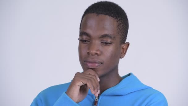 Gezicht van ernstige Afrikaanse jongeman denken en naar beneden te kijken — Stockvideo