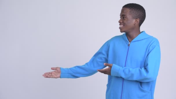 Jeune homme africain heureux montrant quelque chose — Video