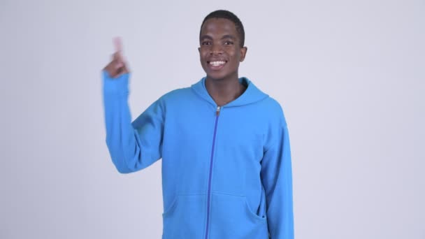 白い背景に 青いパーカーを着ている若いハンサムなアフリカ人のスタジオ撮影 — ストック動画