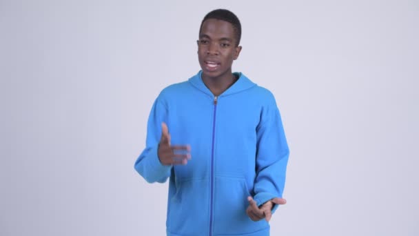 Jonge knappe Afrikaanse man iets uit te leggen — Stockvideo