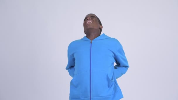 Junger gestresster afrikanischer Mann mit Rückenschmerzen — Stockvideo