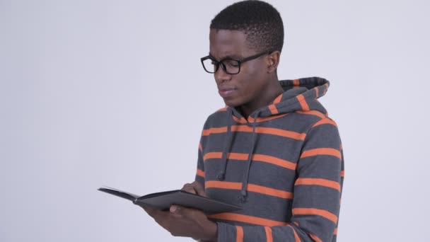 Twarz młodego szczęśliwym człowiekiem Afryki czytając książkę z okularów — Wideo stockowe