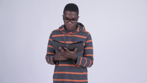Giovane uomo nerd africano che copre il viso con il libro — Video Stock