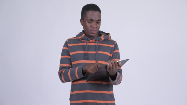 Молодой африканский мужчина со стрессом показывает планшет и показывает большие пальцы вниз — стоковое видео