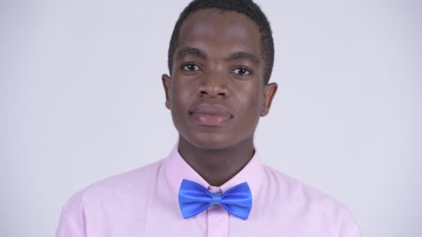 Gezicht van jonge gelukkige Afrikaanse zakenman glimlachend — Stockvideo