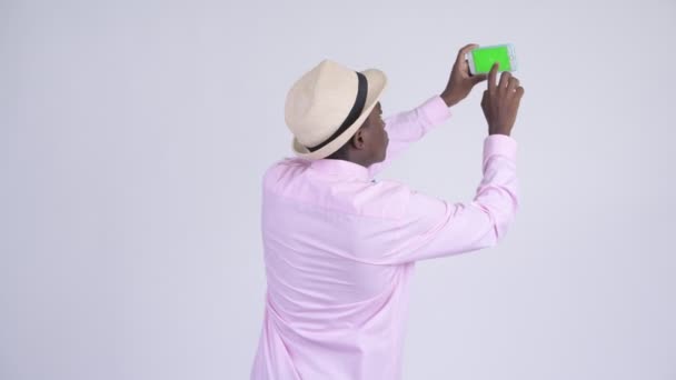 Fiatal, boldog afrikai turista ember képet a telefon hátulnézet — Stock videók
