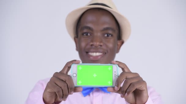 携帯電話を示す若い幸せなアフリカ観光客男の顔 — ストック動画