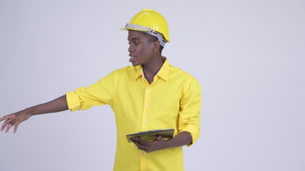 クリップボード上で読みながら説明するエンジニアとして若い幸せなアフリカの実業家 — ストック動画