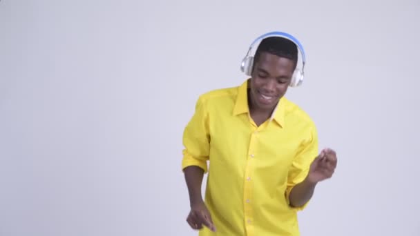 Jonge gelukkig Afrikaanse zakenman dansen en muziek beluisteren — Stockvideo