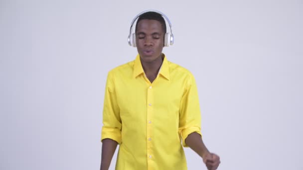 Молодой африканский бизнесмен слушает музыку и выглядит виновным — стоковое видео
