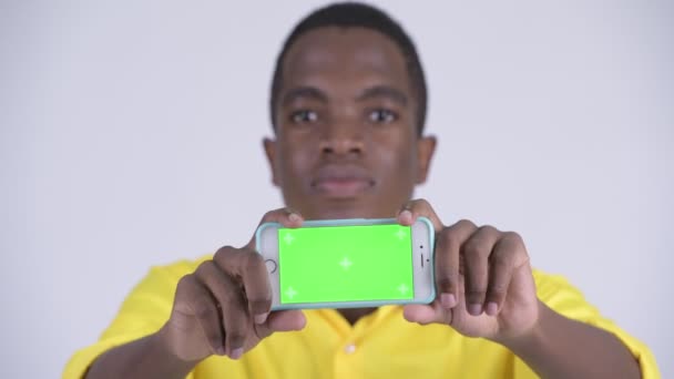 Visage de jeune homme d'affaires africain heureux montrant téléphone — Video
