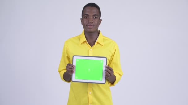 Jeune homme d'affaires africain heureux montrant tablette numérique — Video