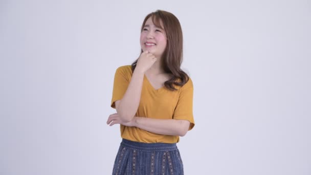 Jovem feliz bela mulher asiática pensando e olhando para cima — Vídeo de Stock