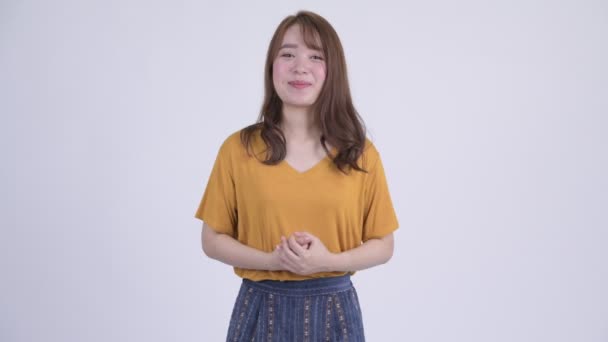 Ευτυχισμένος νεαρή όμορφη γυναίκα Ασίας εξηγώντας κάτι — Αρχείο Βίντεο