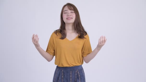 Gelukkig jonge mooie Aziatische vrouw ontspannen met ogen gesloten — Stockvideo