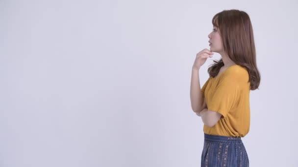 Hossz-szelvény nézet boldog fiatal gyönyörű ázsiai nő gondolkodás — Stock videók