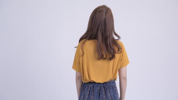 Вид сзади на молодую красивую азиатку, ждущую и думающую — стоковое видео